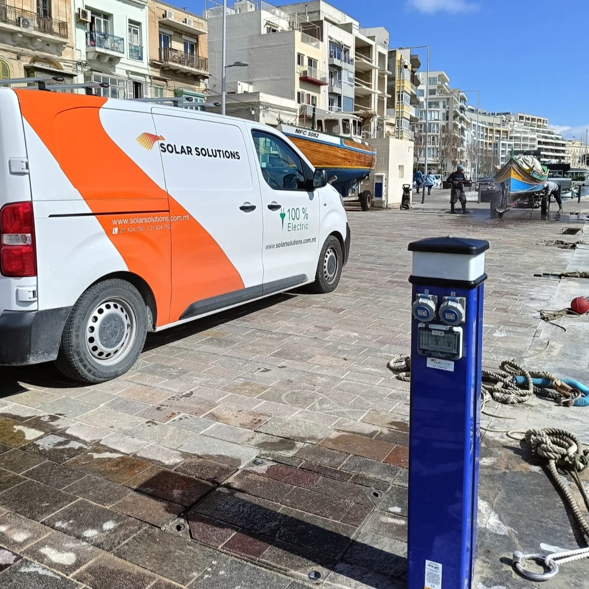Blue BasicCharge charger installed next to a Solar Solutions van